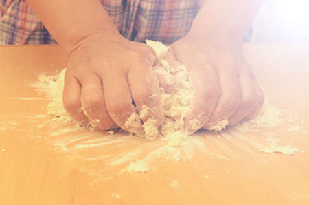 A woman kneads a homemade dough for pizza production