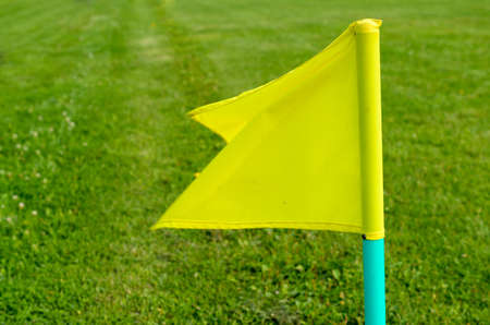 Yellow flags on the green grass of a football playing fieldの写真素材