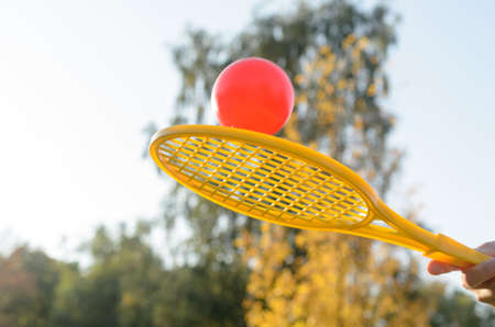 A tennis racket in his hand catches the ball in motionの写真素材