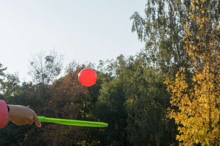 A tennis racket in his hand catches the ball in motion