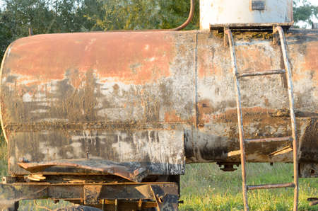 An old dirty barrel on wheels at the edge of the roadの写真素材