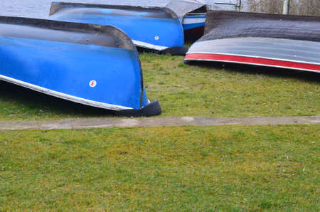 Inverted multicolored boats dry on the shore.の写真素材
