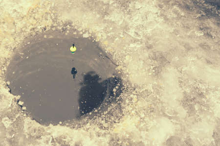 Round ice in the ice with a float on the lineの写真素材