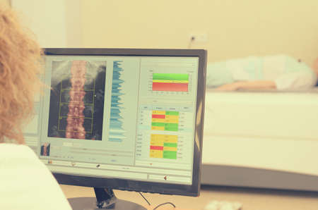 A woman x-ray examines the results of densitometryの写真素材