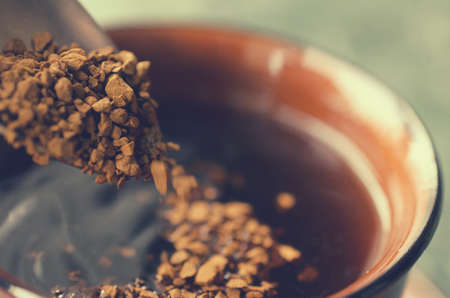 Spoon the granulated coffee into a cup for coffee