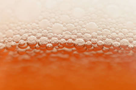 Bubbles from a beer froth close-up on half a glass.の写真素材