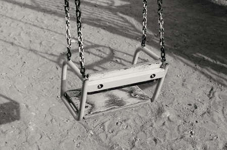 Children's swing is empty on the playgrounの写真素材