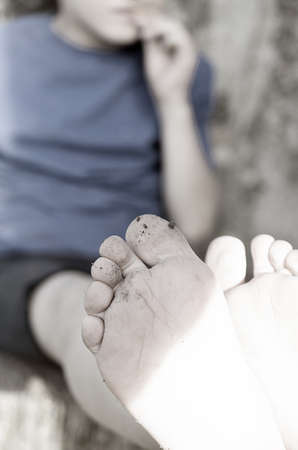 A hungry dirty boy greedily eats a crust of bread against the wallの写真素材