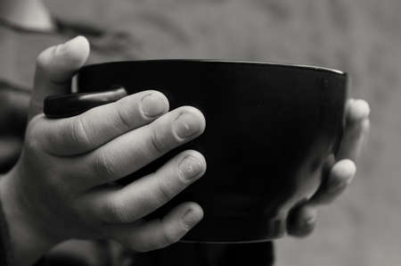 The palms of the hungry boy hold an empty plateの写真素材