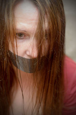 The mouth of a young woman sealed with an adhesive tape. The right to vote is a political and social problemの写真素材