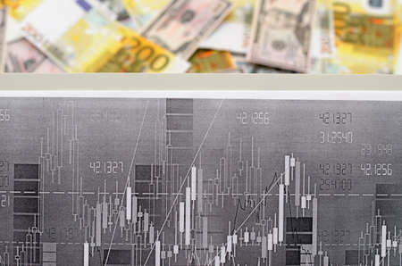 Money against the background of financial stock chartsの写真素材