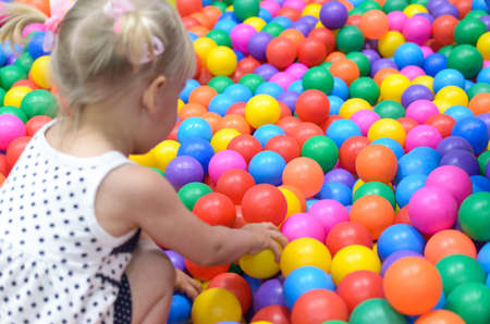 A girl in the playroom, where there are a lot of colored ballsの写真素材