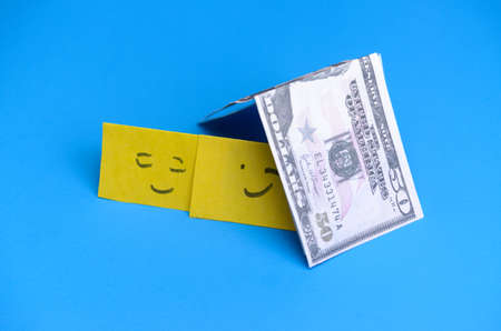 Smiling yellow smileys in the house of money. The concept of loans for the family
