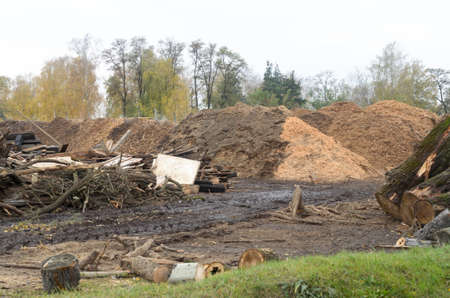 Waste sawmill in the form of a stack of boards and a mountain of sawdust