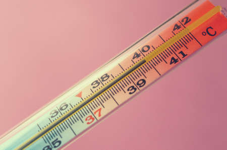 Medical mercury thermometer on a pink backgroundの写真素材