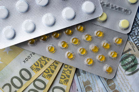 Tablets and banknotes. The concept of imposing medical drugs