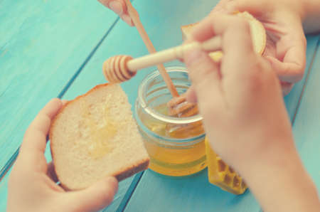 Honey and honey accessories for its use on a blue wooden background.の写真素材