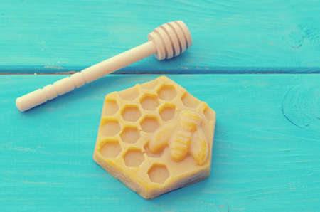 Honey and honey accessories for its use on a blue wooden background.
