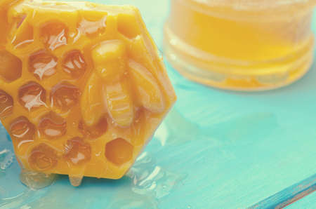 Honey and honey accessories for its use on a blue wooden background.