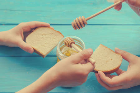 Honey and honey accessories for its use on a blue wooden backgroundの写真素材