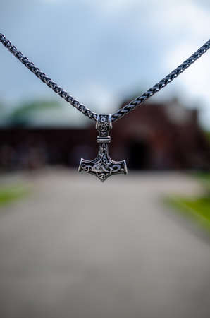 Thors hammer as a symbol of war against the backdrop of destruction.
