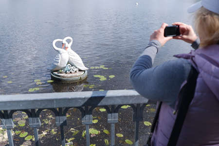 A girl in a white cap takes pictures of the water landscape with a camera. St. Veronicas Day...