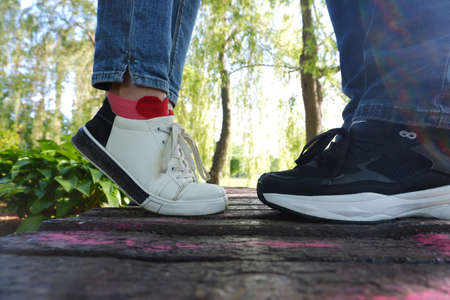 Legs of kissing man and woman in sports shoes. World Kiss Day.の写真素材