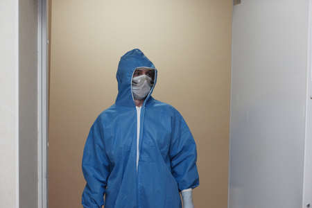 The work of a radiologist in antiviral overalls in the X-ray room for diagnostics.