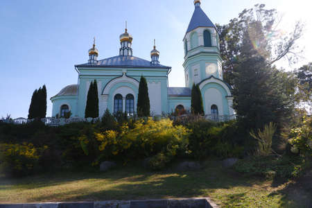 Magnificent turquoise Orthodox church in the rays of the setting sun.のeditorial素材