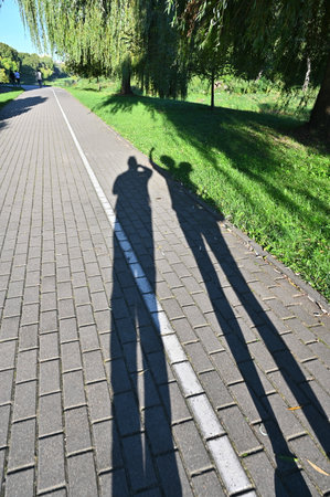 Shadows of two people on the sidewalk.の写真素材