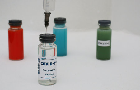 White, red, green and blue ampoule with vaccine.