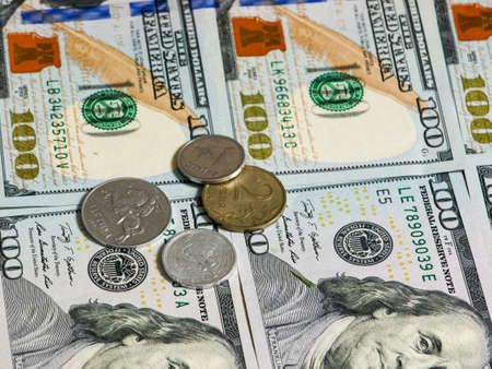 Dollar banknotes and coins. Lithuanian, Russian, Chinese coins lie on dollar banknotes.