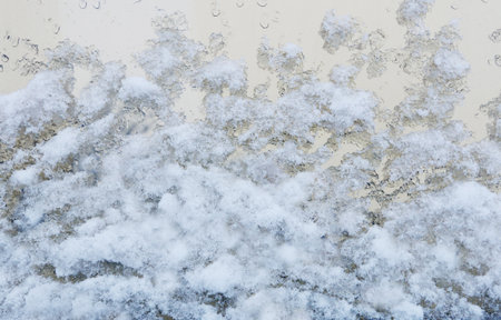 Image of melting snow on the glass of a large window.の写真素材