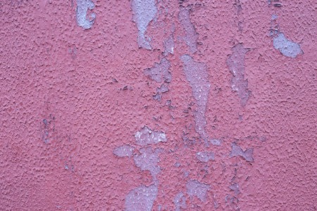 Old peeling wall with time-damaged red paint.