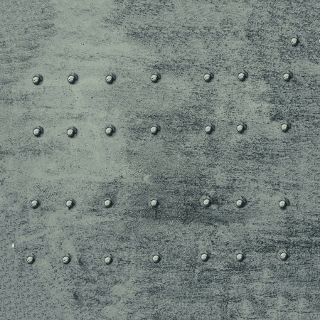 Old metal background with rivets. Rusty surface with rivets of a metal wall.