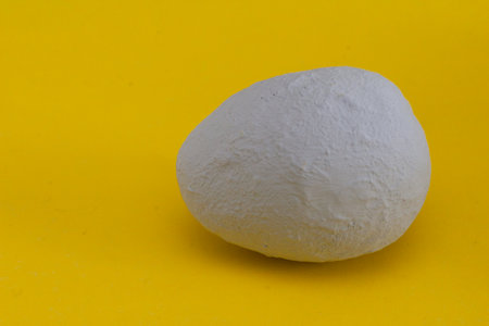 happy easter card background idea. Easter decorative egg painted by hand in gray paint on a bright yellow background.の写真素材