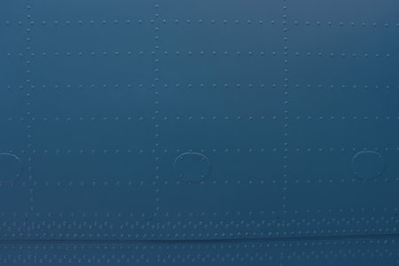 Riveted metal from an aircraft. Aircraft skin close up. Abstract blue metal background with studs.の写真素材