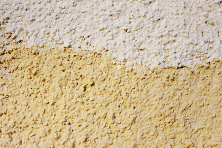 Abstract background of orange and beige paint on the wall close-up. The fong is half painted in different colors.の写真素材