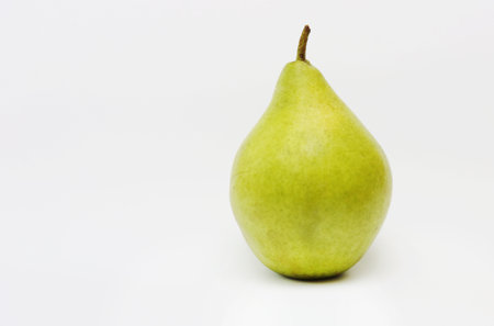 Green pear close-up on a white background...Image of an unripe yellow-green pear.の写真素材