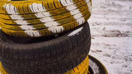 Old unusable tires painted with yellow paint close-up