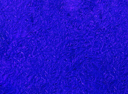 blue crumpled foil surface close-up. Abstract blue foil background close up.