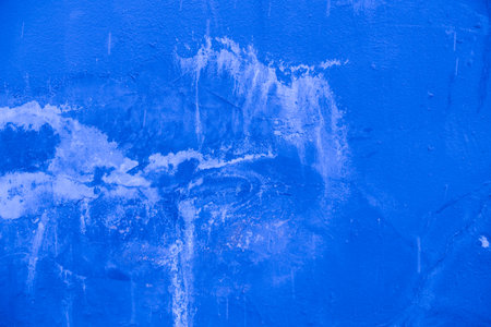 Textured blue plaster background with scratches and stains.の写真素材