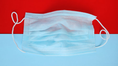 Medical mask on a red and blue background. Coronavirus concept.