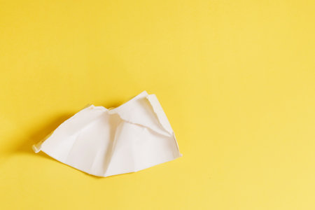 Damaged, unusable disposable plastic cup on a yellow background.の写真素材
