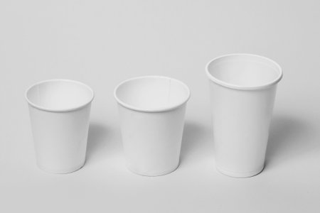 Three white paper disposable cups on a white background.の写真素材