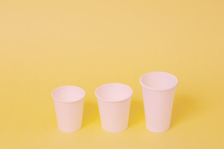 Take away a cup of coffee on orange paper background.の写真素材