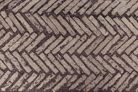 Old antique sidewalk made of decorative stone tiles.