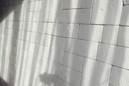 Abstract weathered texture stained old stucco light gray and aged paint white brick wall background in rural room, grungy rusty blocks of stonework technology color horizontal architecture wallpaperの写真素材
