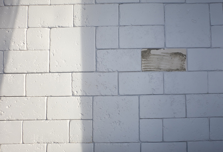 Abstract weathered texture stained old stucco light gray and aged paint white brick wall background in rural room, grungy rusty blocks of stonework technology color horizontal architecture wallpaperの写真素材
