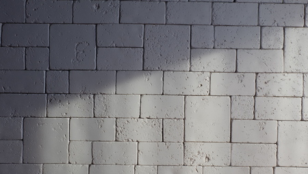Abstract weathered texture stained old stucco light gray and aged paint white brick wall background in rural room, grungy rusty blocks of stonework technology color horizontal architecture wallpaperの写真素材